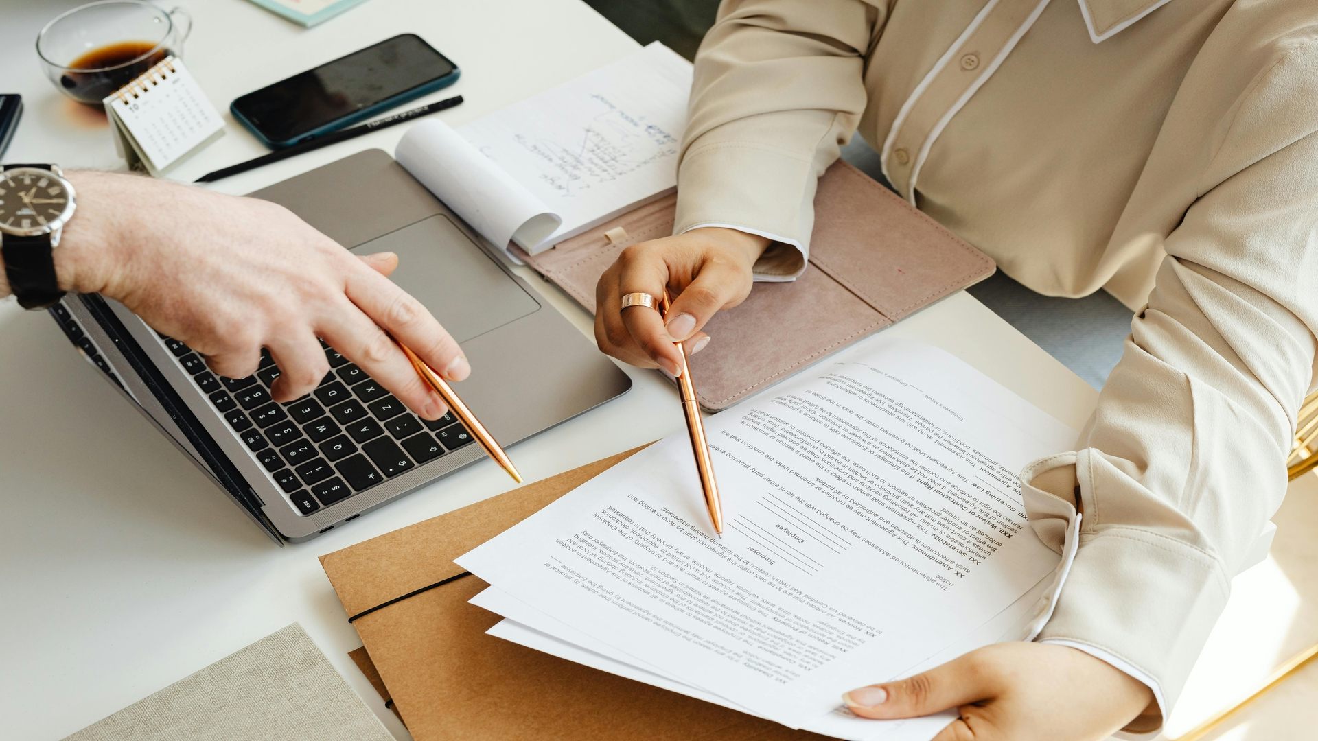 Bureau avec documents fiscaux 2025 et deux personnes qui en débattent