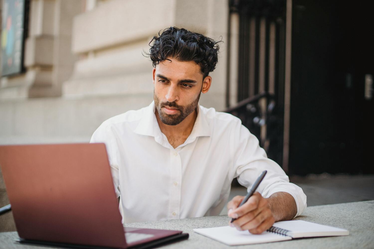Homme notant les dates de déclarations fiscales en regardant son ordinateur