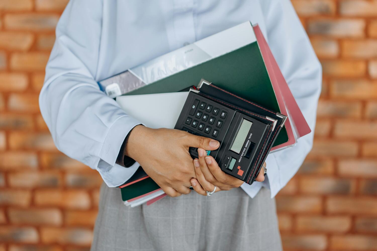 Personne tenant des dossiers et une calculatrice pour faire sa déclaration fiscale